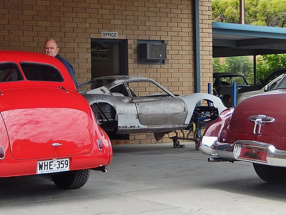 Cars mid-restoration outside a body shop